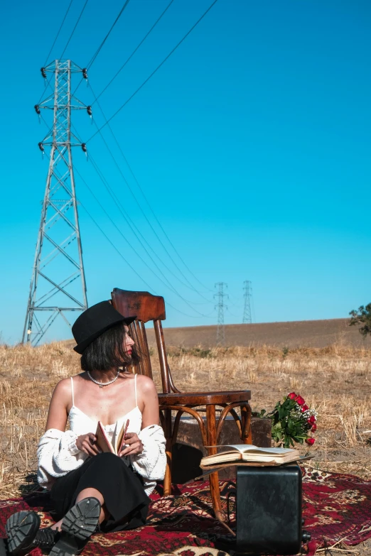 a woman with long hair sitting on a rug with an old chair