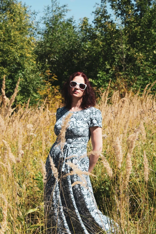 woman in large blue dress standing in a field