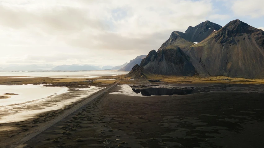 a long dirt road is at the foot of a mountain