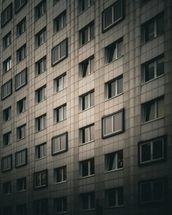 the facade of a tall building has many windows