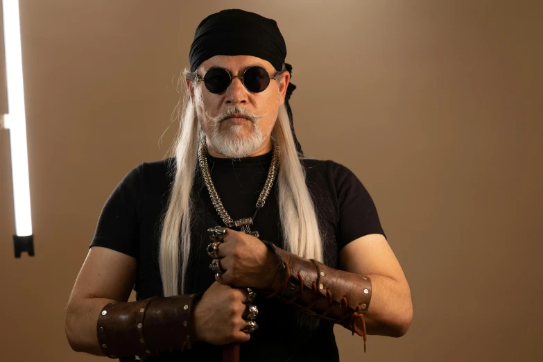 a male with white hair in sunglasses and some wrist chains