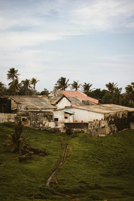 a building sitting on top of a lush green hillside