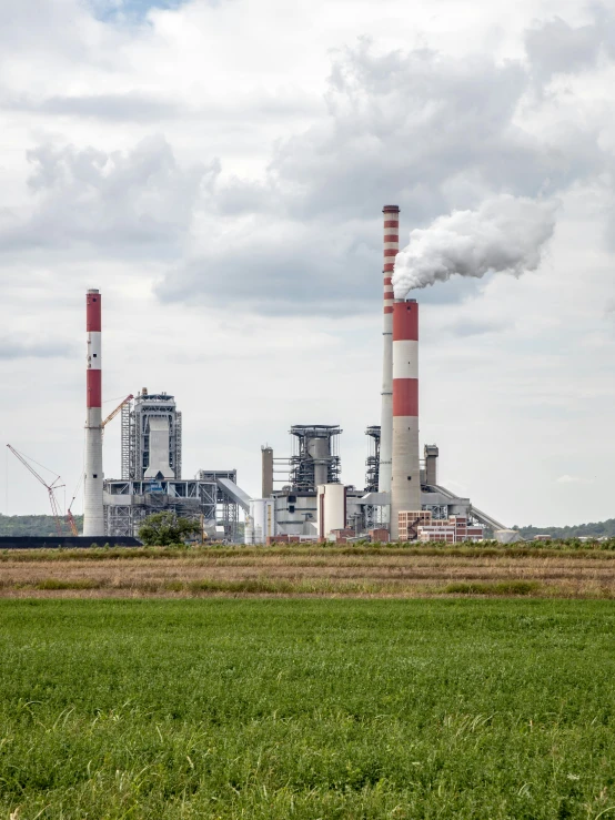 a factory building and smoke stacks in the sky