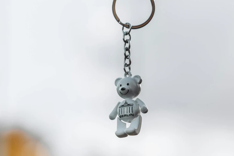 a keychain with a bear and some sort of symbol