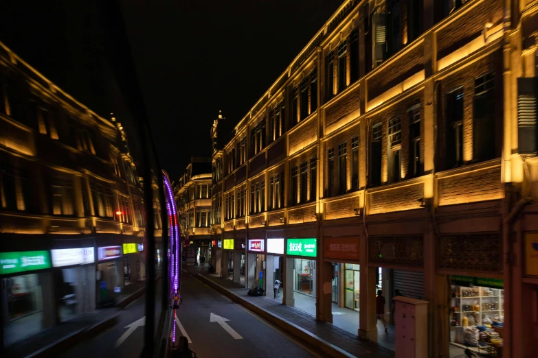 a city street at night with a very large building