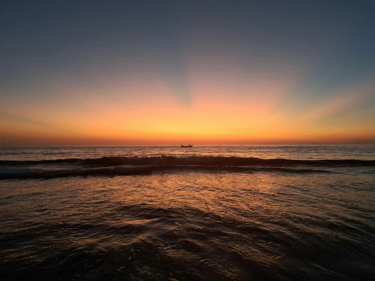 sun coming up over the ocean with waves