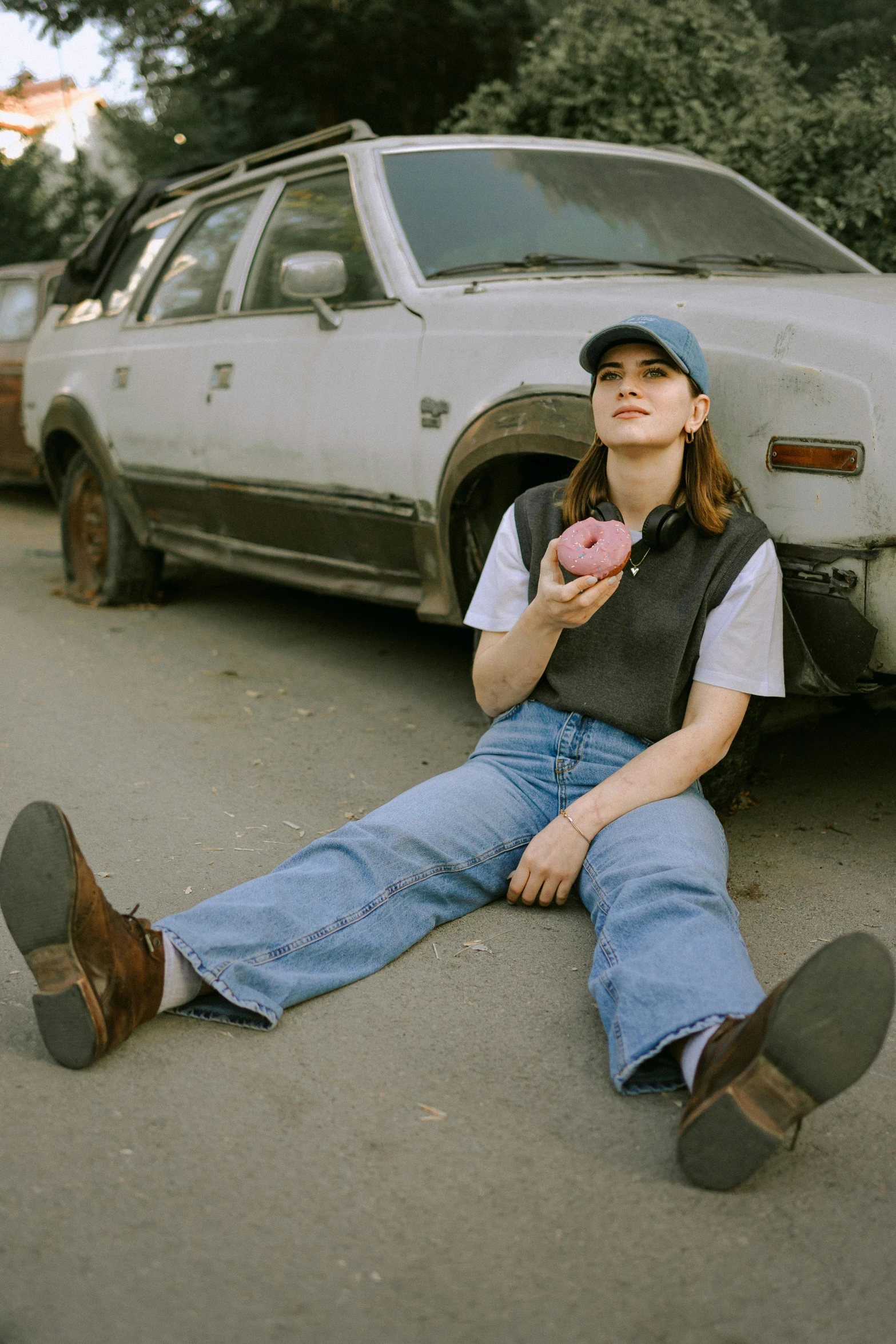 a woman sitting on the ground in front of a car