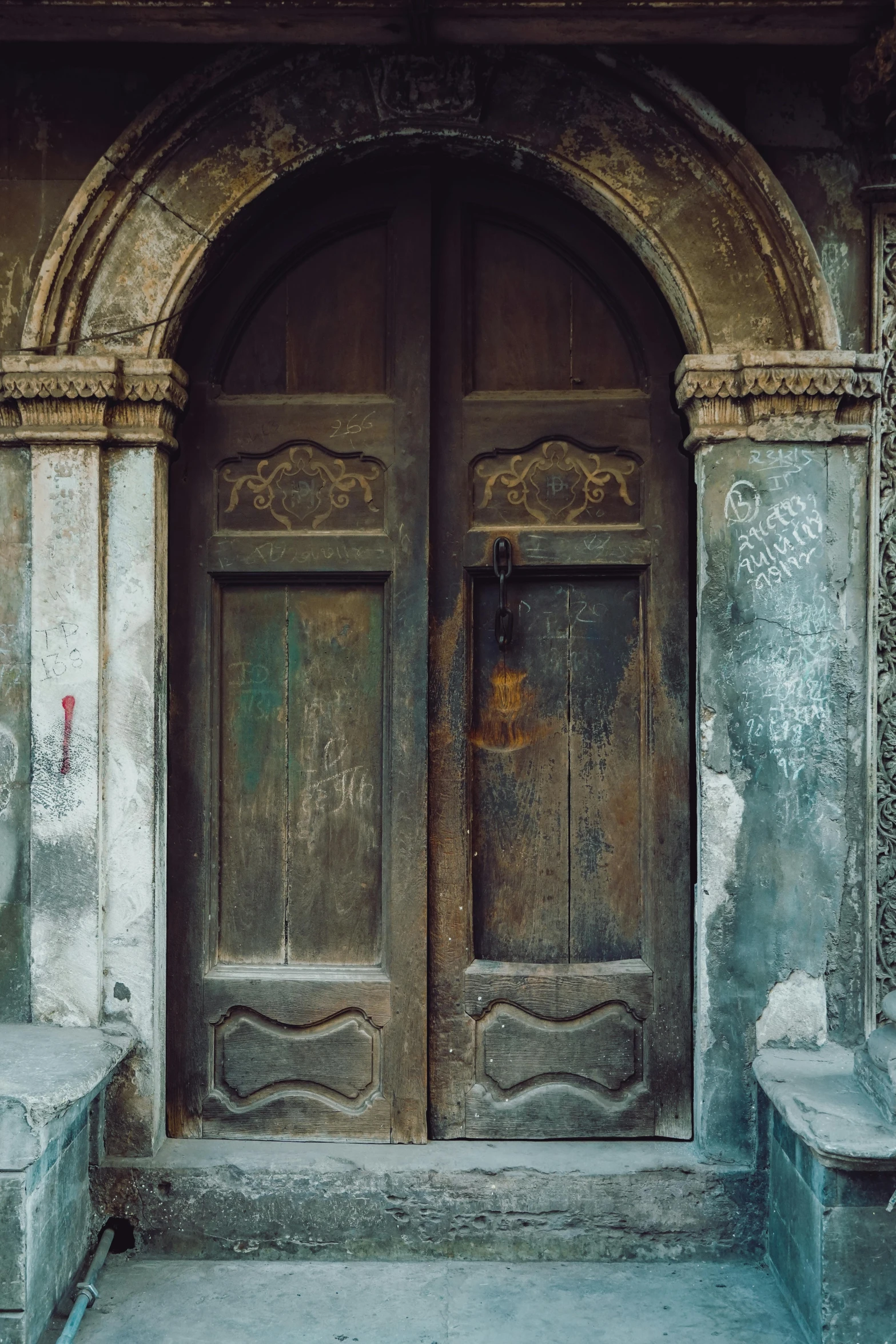 two old door with pillars on an aged building