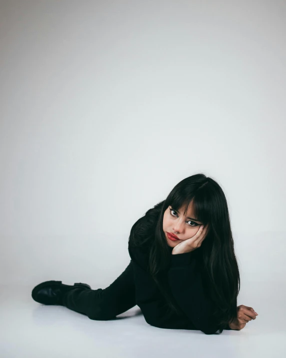 a woman with black stockings posing in front of white wall