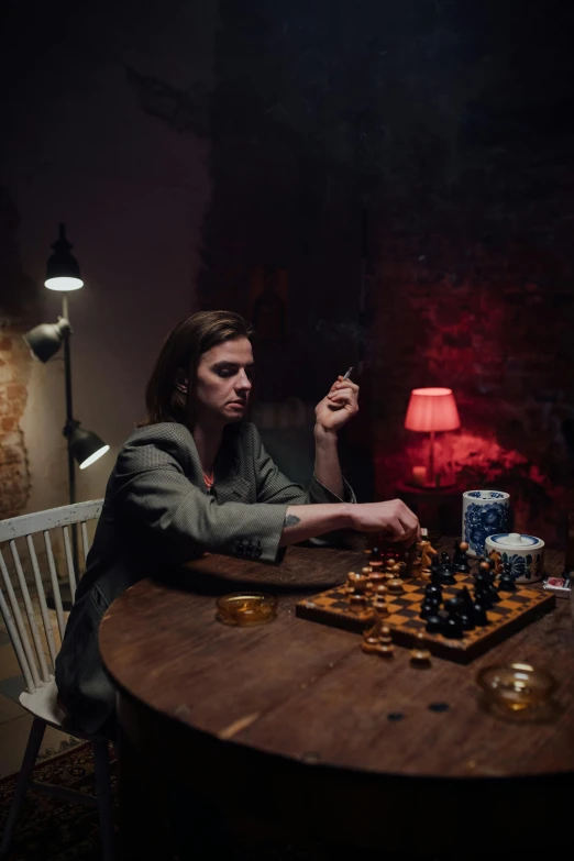 a woman sitting at a table in front of her chess game