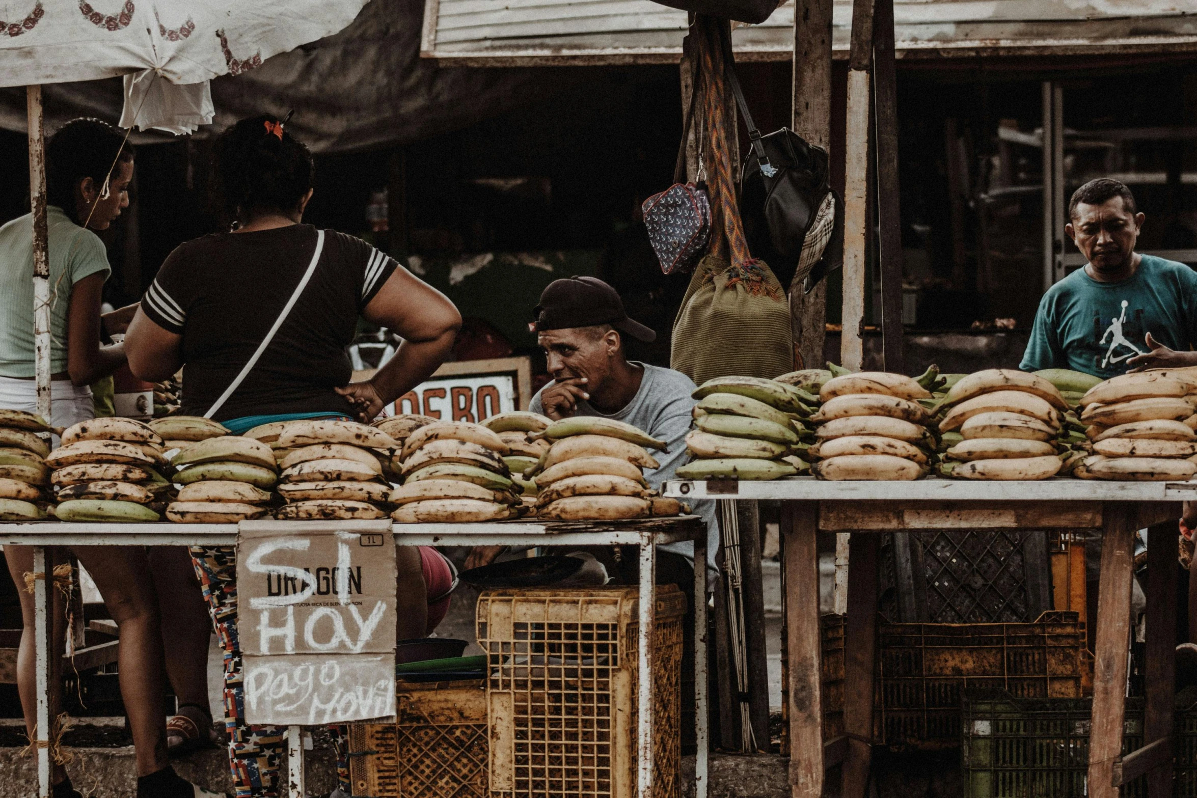 people are in a market selling sandwiches