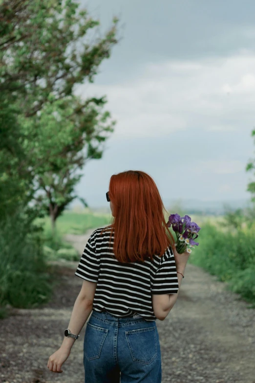 the woman in black and white shirt is carrying flowers