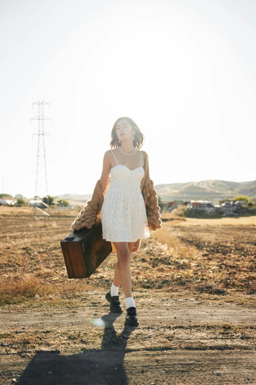 a woman walking down a road in an open field