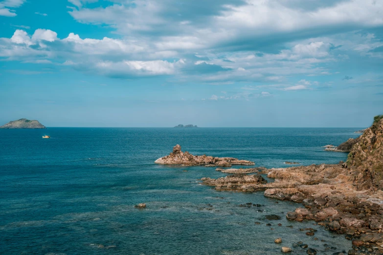 there is a blue sea and a rock on the side of it