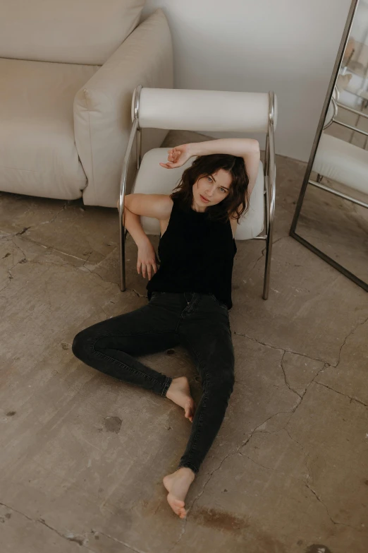 a woman is laying on the floor in a living room with mirrored furniture