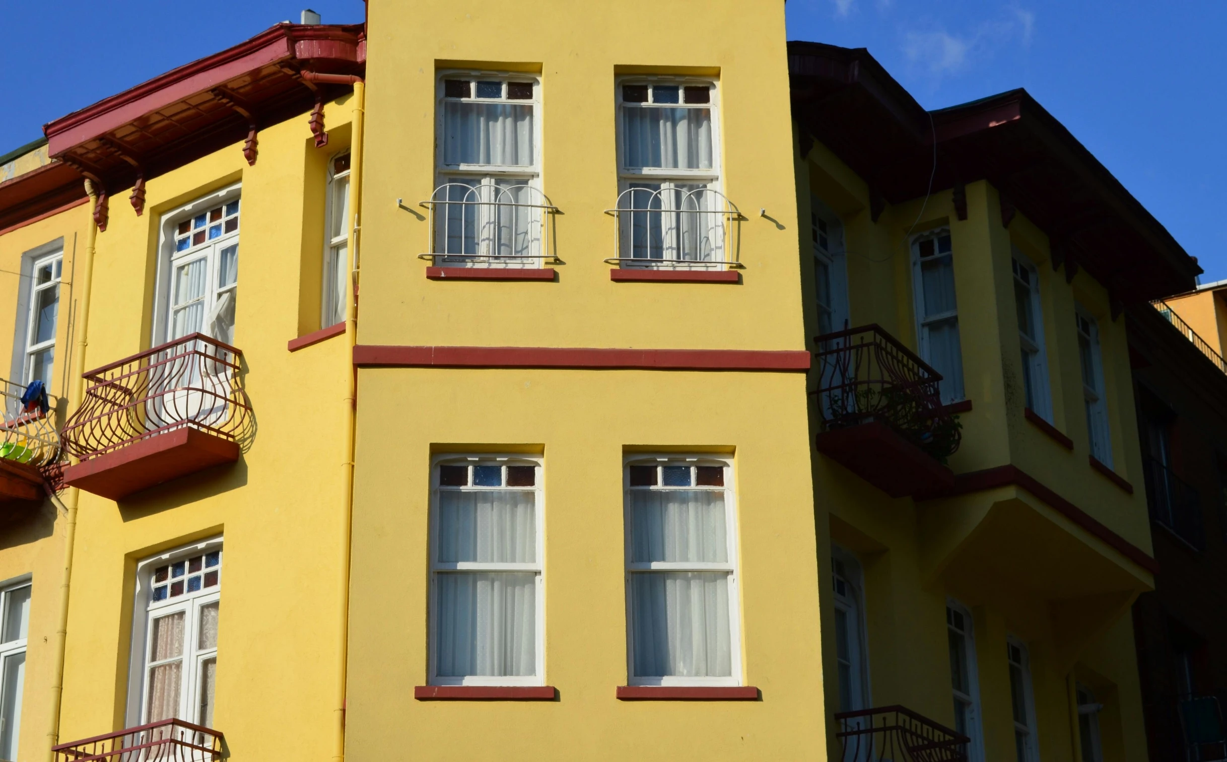 two tall yellow and red building with balconies