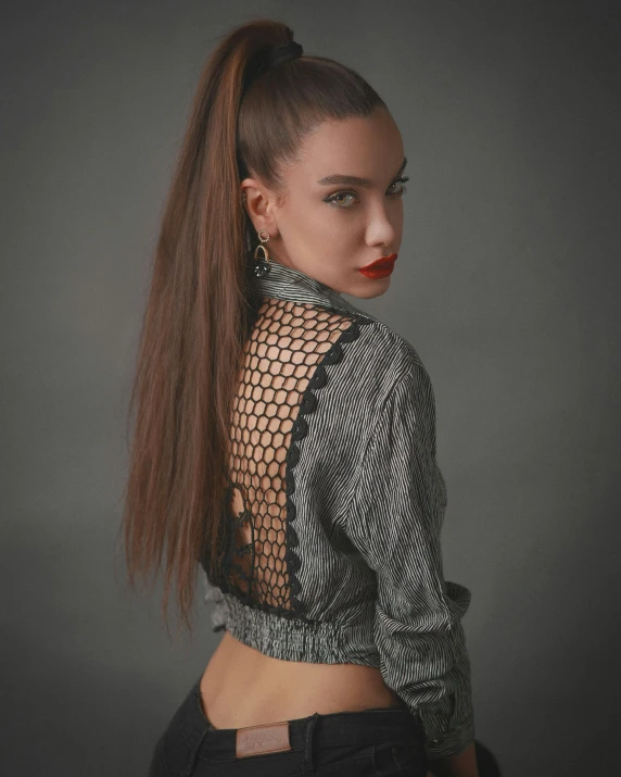 the back of a woman's head with a id and high ponytail, wearing a turtle neck top