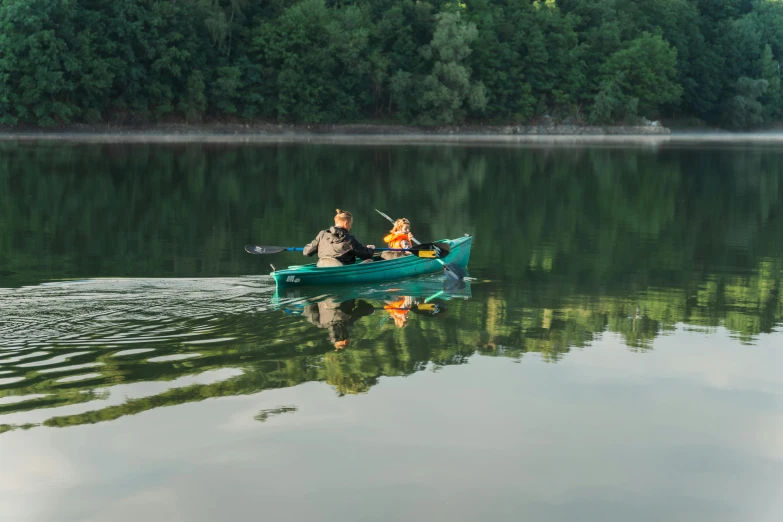 two people rowing in a boat on the water