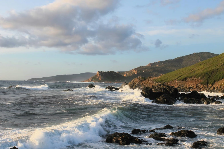 the ocean waves hit up on the beach