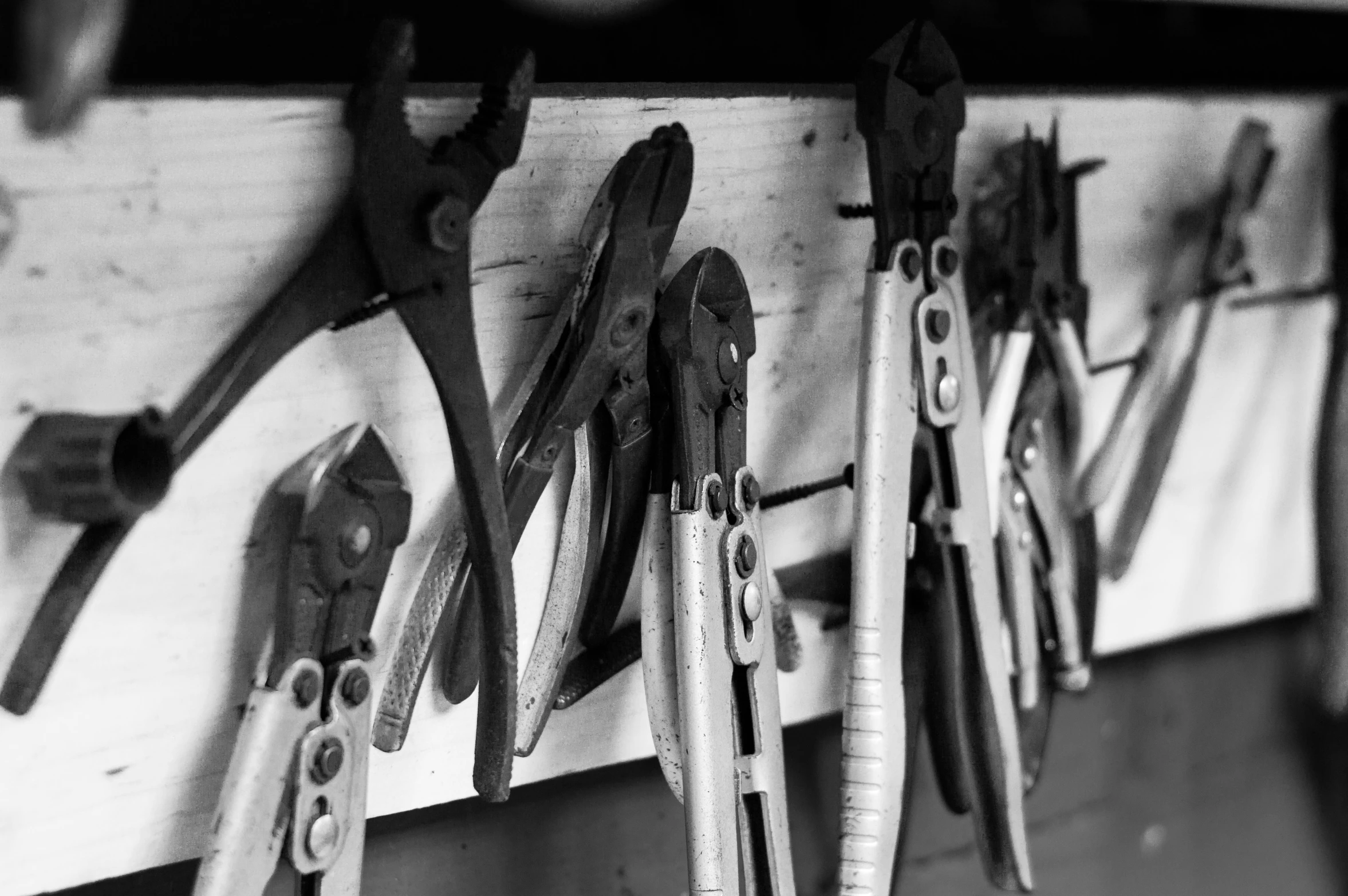 a bunch of metal tools hanging on a wall