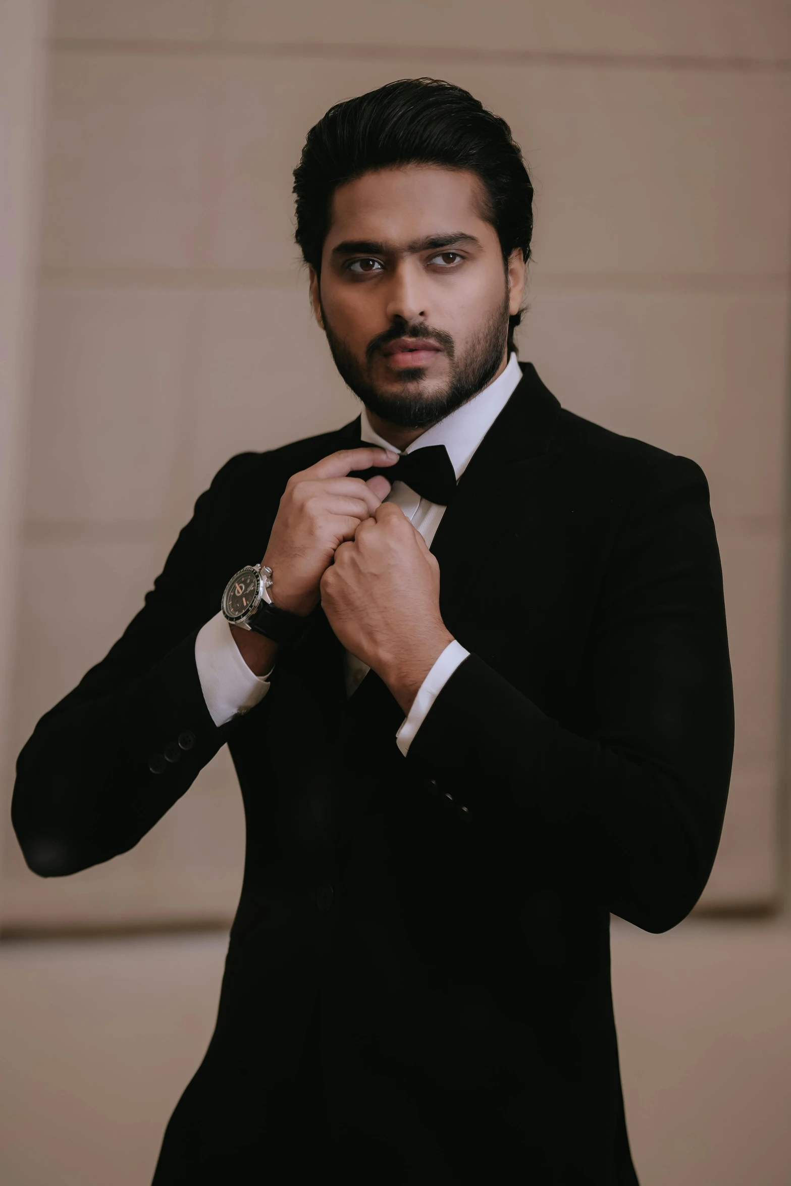 man adjusting his dress shirt in black suit