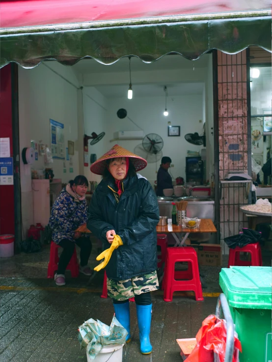 a person standing in front of a shop with a hat on