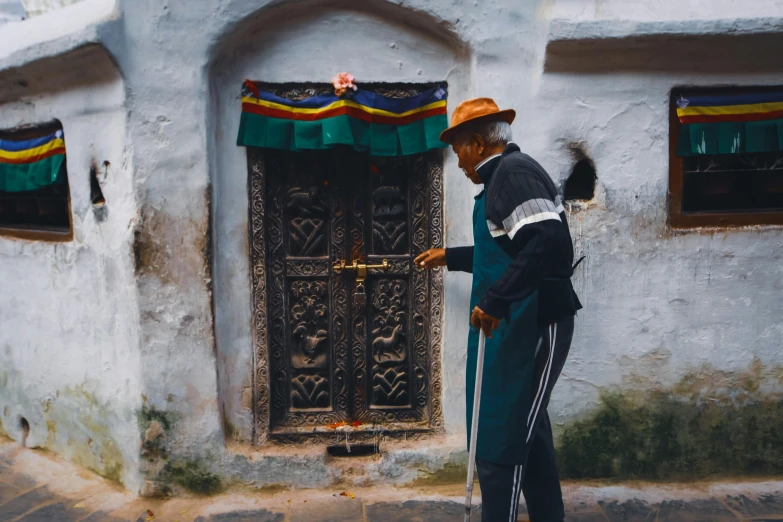 a person that is by some buildings and wearing a hat