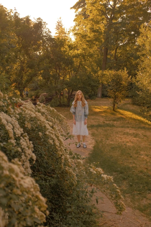 a woman is walking on a path in the woods