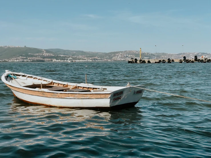 an old boat sits in the middle of the ocean