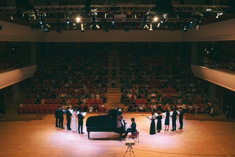 two pianos on stage with a large group of people