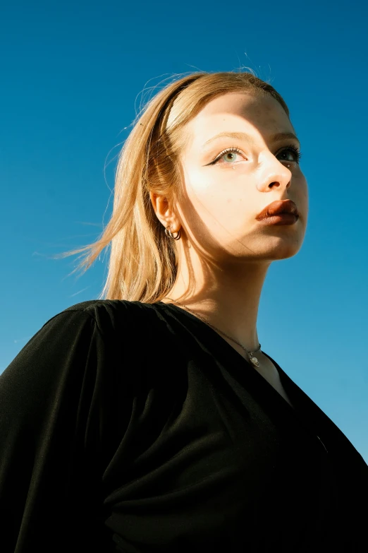 a female in a black shirt and earrings