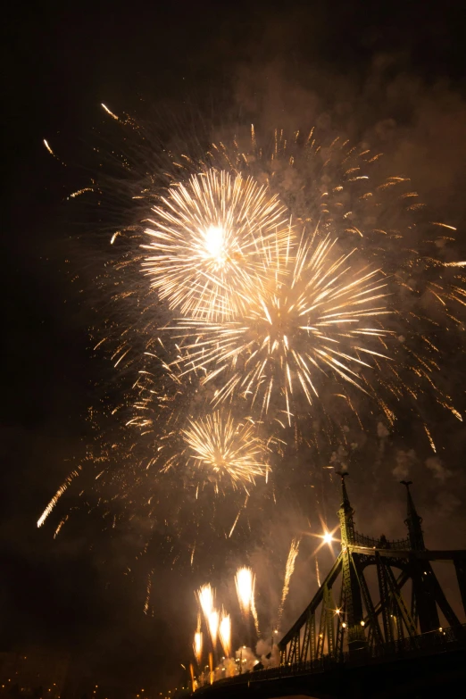 some very nice fireworks in the sky over a bridge