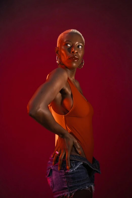 a black woman with red makeup standing in front of a dark background