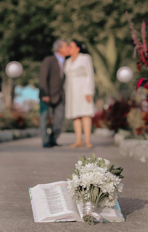 an open book with a wedding flower and the cover turned upside down