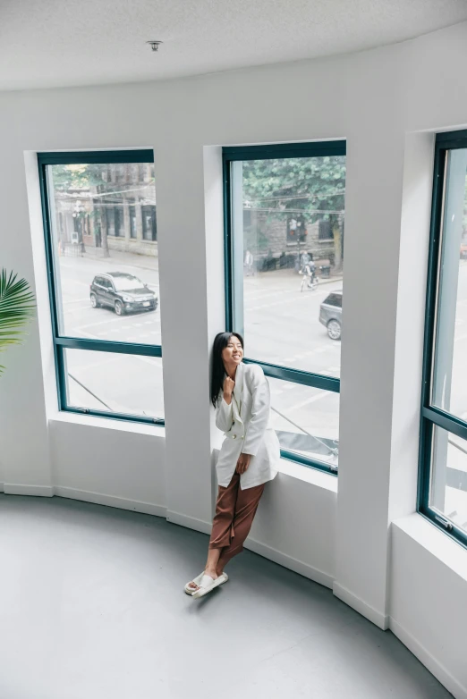 woman standing on a circular window ledge in front of multiple windows