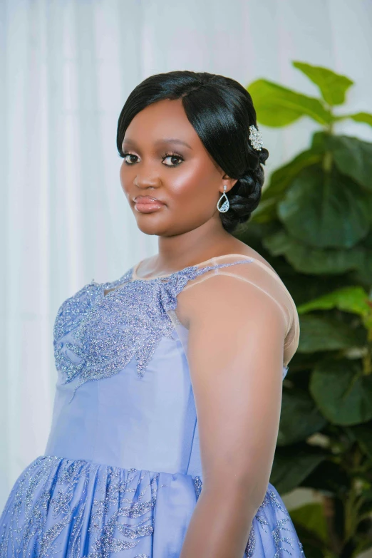 a beautiful young woman in a blue dress looking at the camera