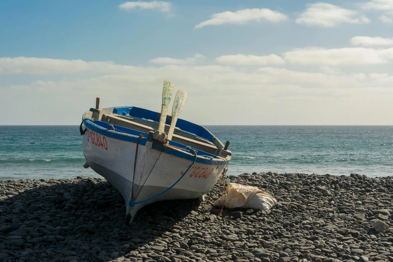 an old fishing boat sitting on top of rocks