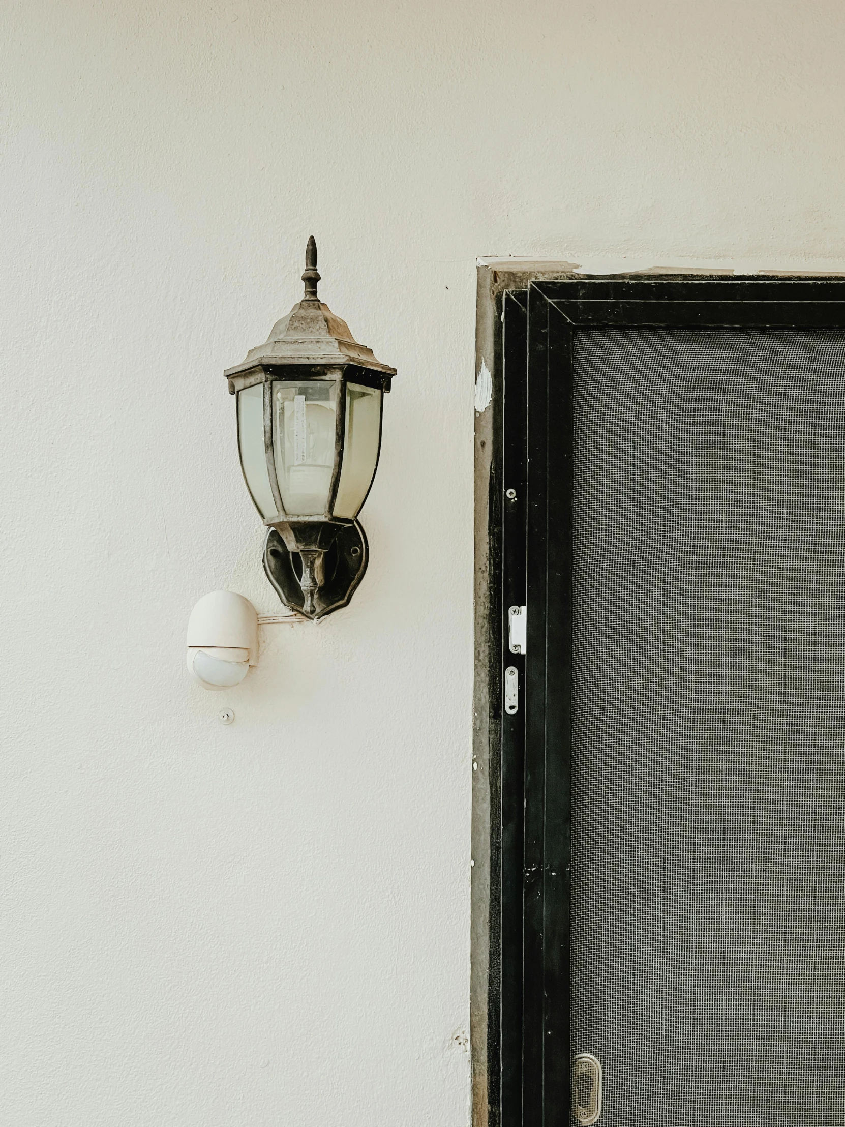 a small light next to a door on the wall