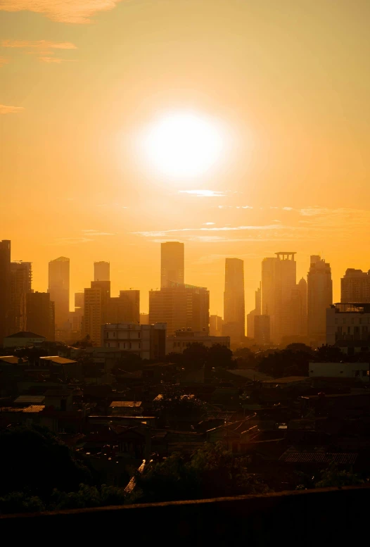 the sun is setting over a city that is tall