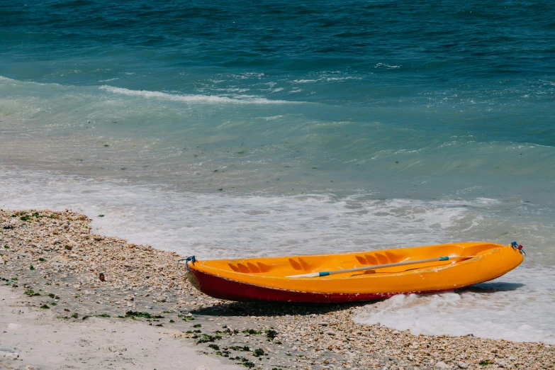 an orange boat is resting on the shore