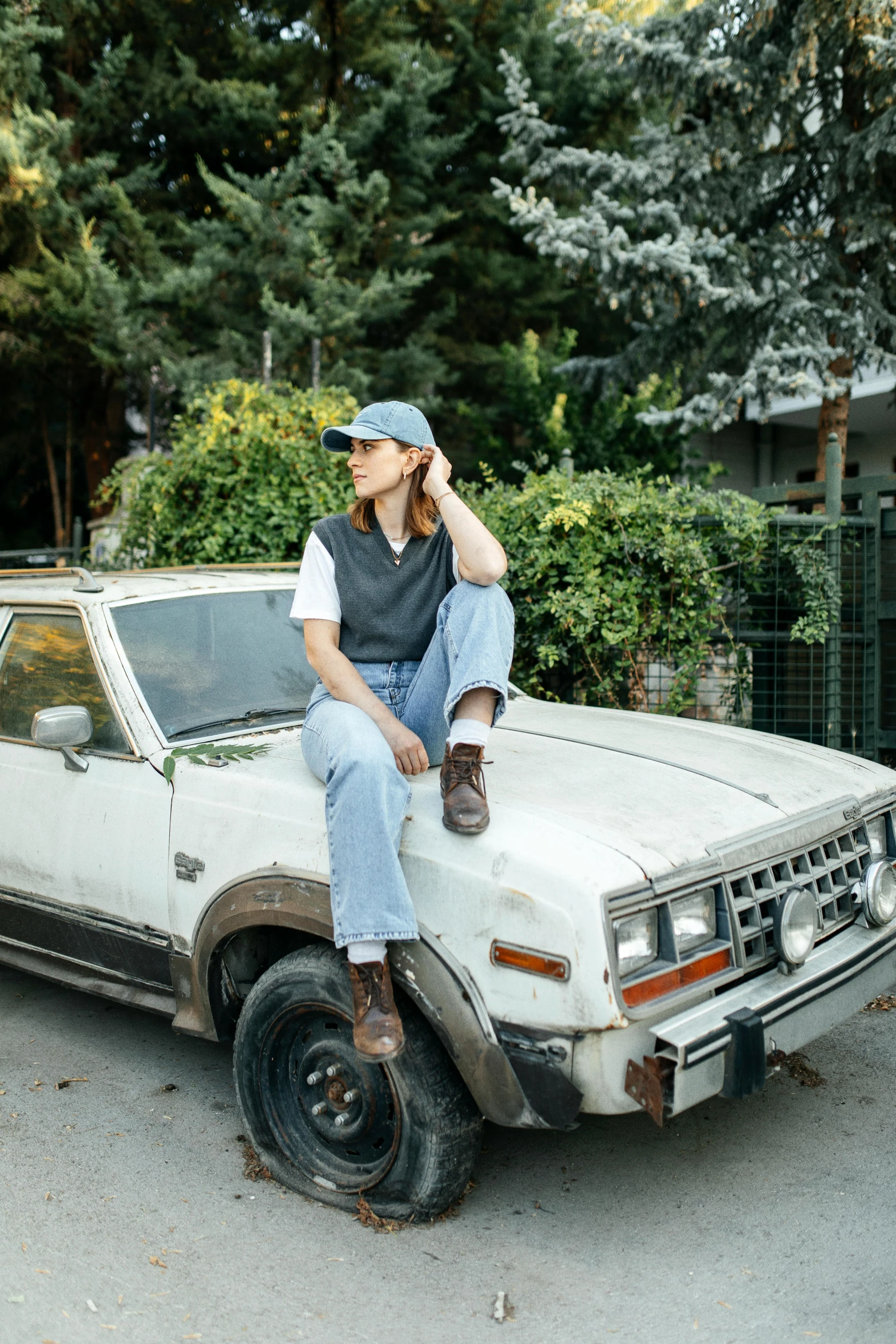 a woman sits on the hood of her truck