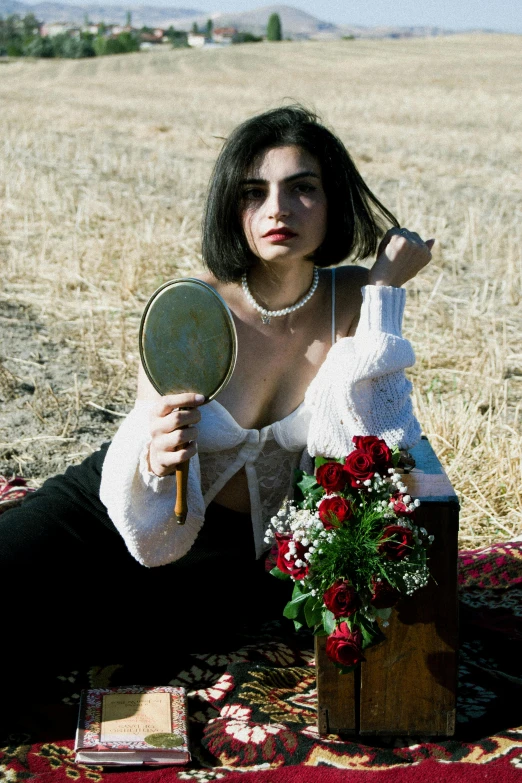 a young lady sitting on the ground with a magnifying glass