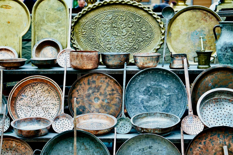 a display case filled with metal pots and pans