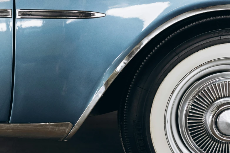 the front end of an old blue car with chrome accents