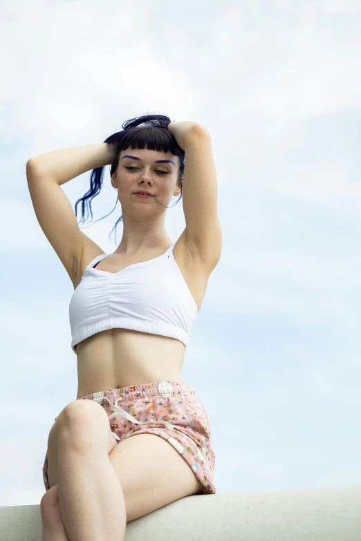 a woman sitting with her hands on top of her head