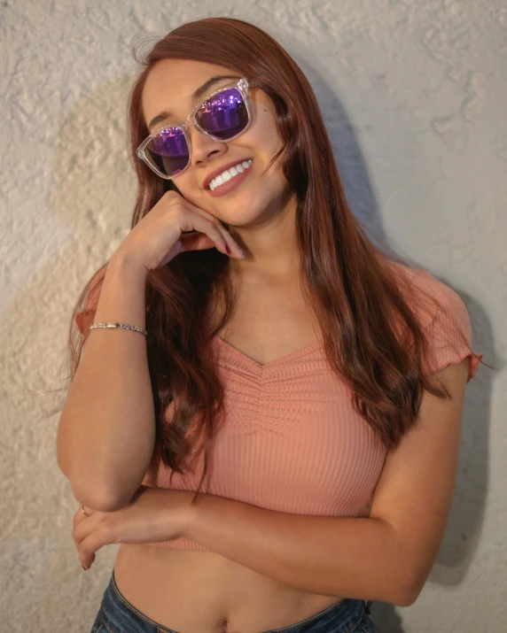 a smiling woman in sunglasses poses for a po