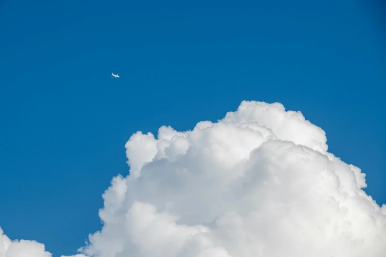 a small plane flying in the sky above clouds