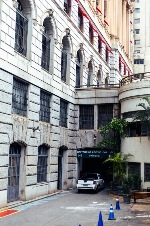 a white car parked in a parking space in front of a tall building