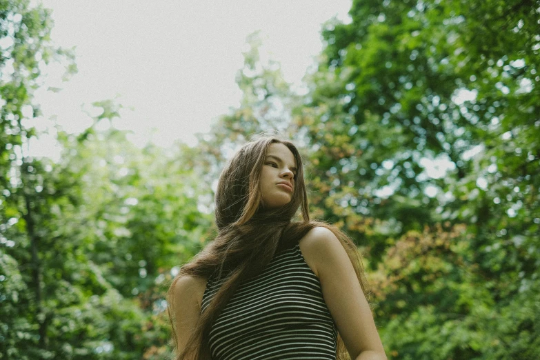 young woman in green and black striped top holding soing