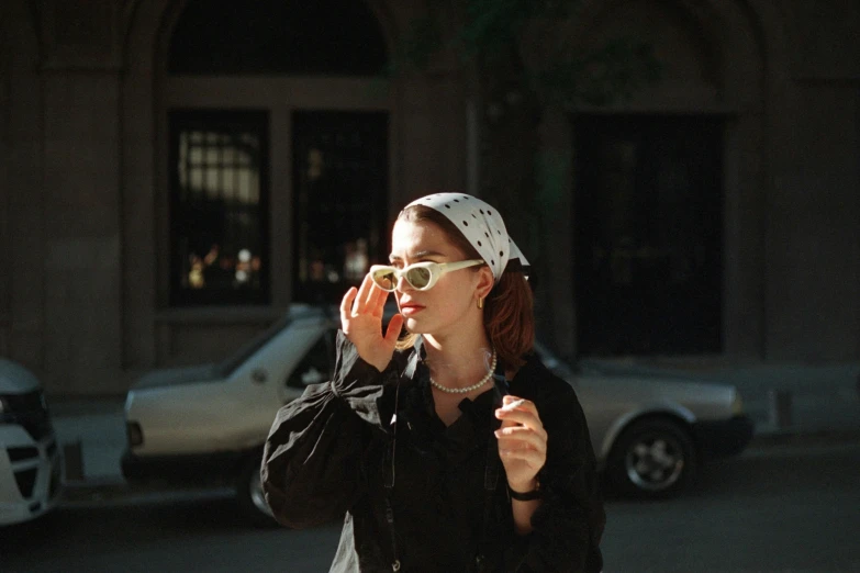 a woman in black jacket on cell phone and sunglasses